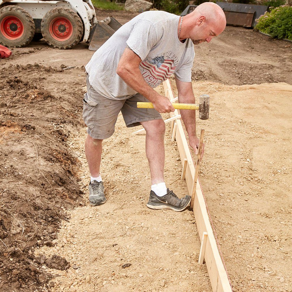 Pounding form stakes into the ground | Construction Pro Tips