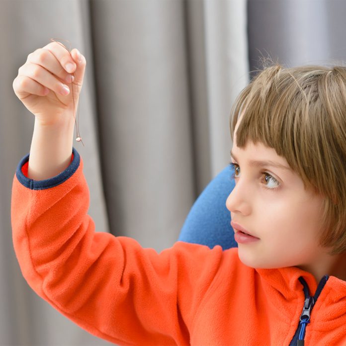 kid holding tooth tied to floss