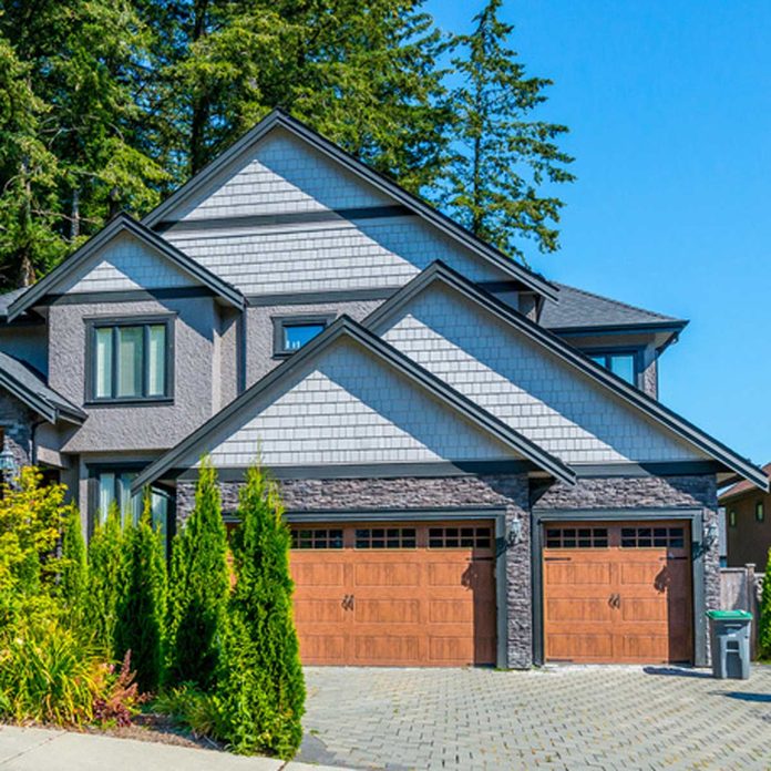 traditional home with dark trim and wooden garage doors