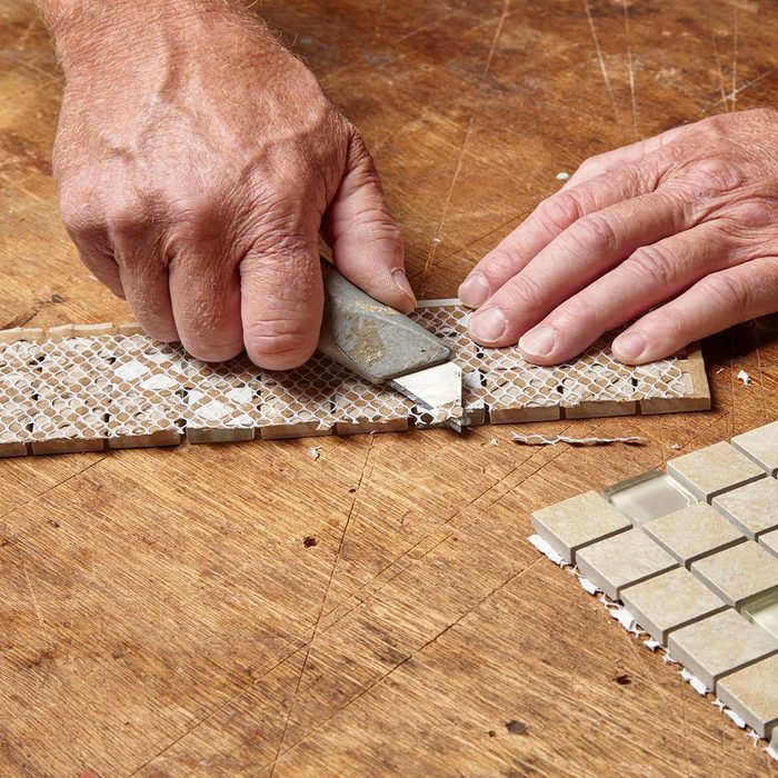 cutting off the extra strands of tile backer | Construction Pro Tip