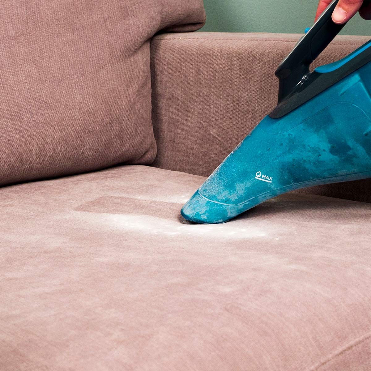 vacuuming up baking soda from upholstery