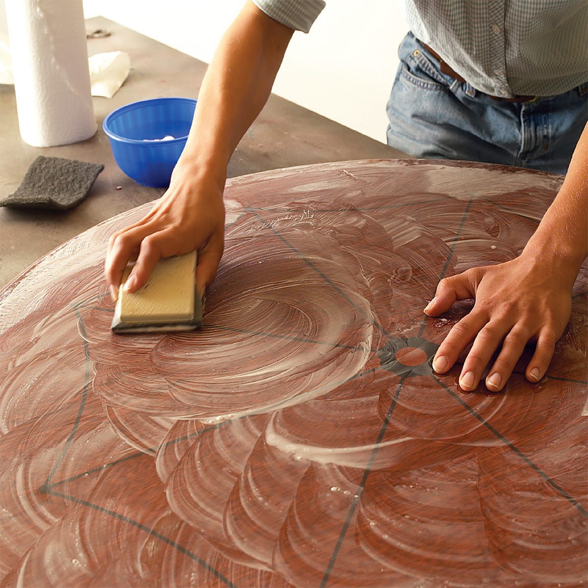 Man sanding table top with sand paper and soapy water | Construction Pro Tips