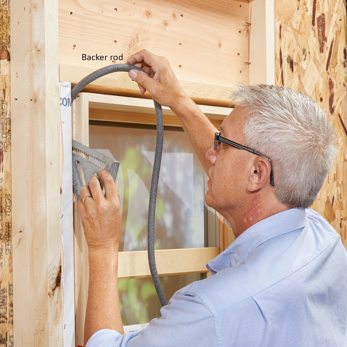 Man installing backer rod in window cavities | Construction Pro Tips