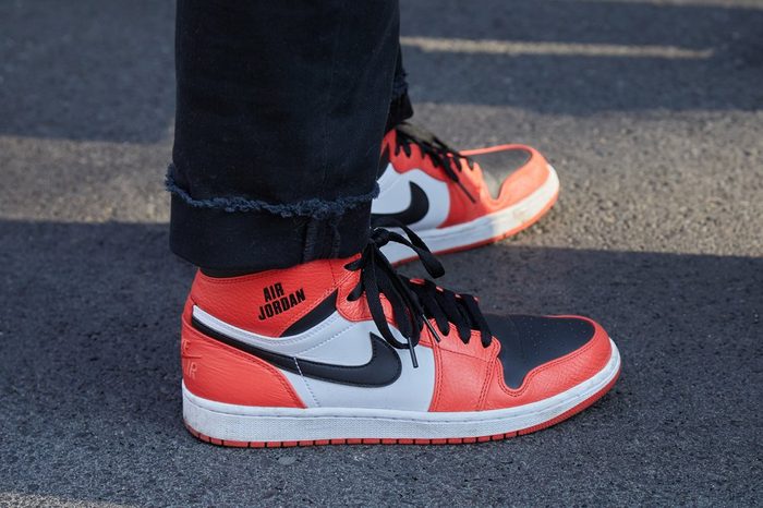  MILAN - FEBRUARY 27: Man with orange Nike Air Jordan shoes before Giorgio Armani fashion show, Milan Fashion Week street style on February 27, 2017 in Milan. 