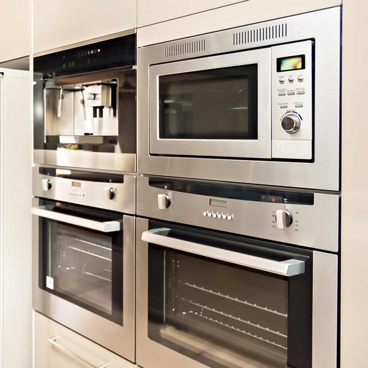 Luxurious kitchenware including silver oven and refrigerator in the kitchen which has a wooden floor, Pantry cupboards are light brown color and installed around the cooker and fridge. ; Shutterstock ID 469237499