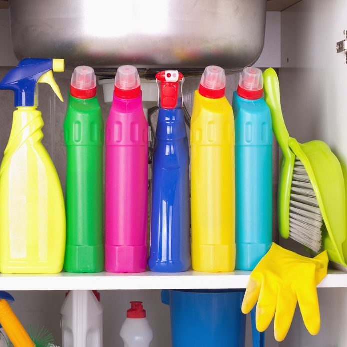 Cleaning products placed in kitchen cabinet under sink. Housekeeping storage space