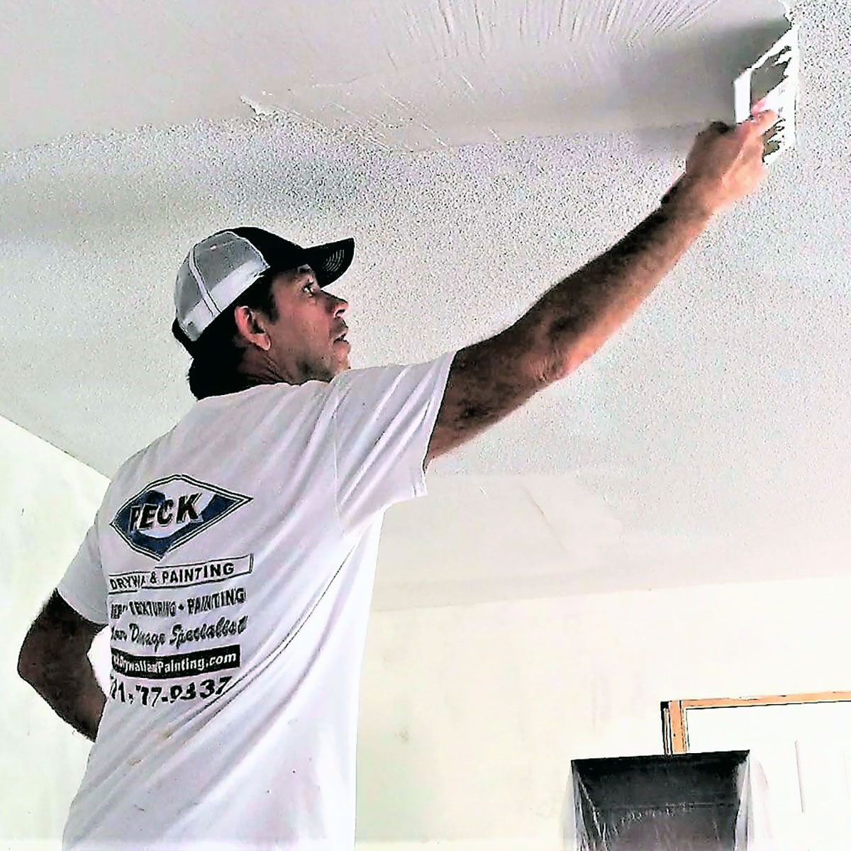 Man applying skim coating to a ceiling | Construction Pro Tips