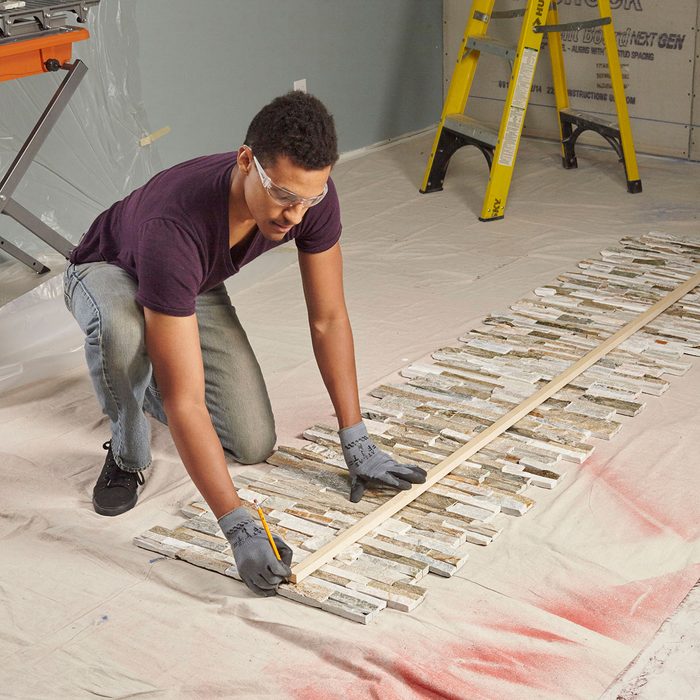 Drawing a scoring line across the face of the stone