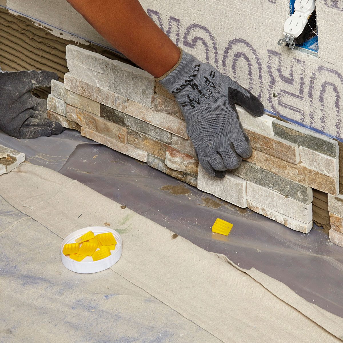 Place stone pieces along the bottom line of accent wall