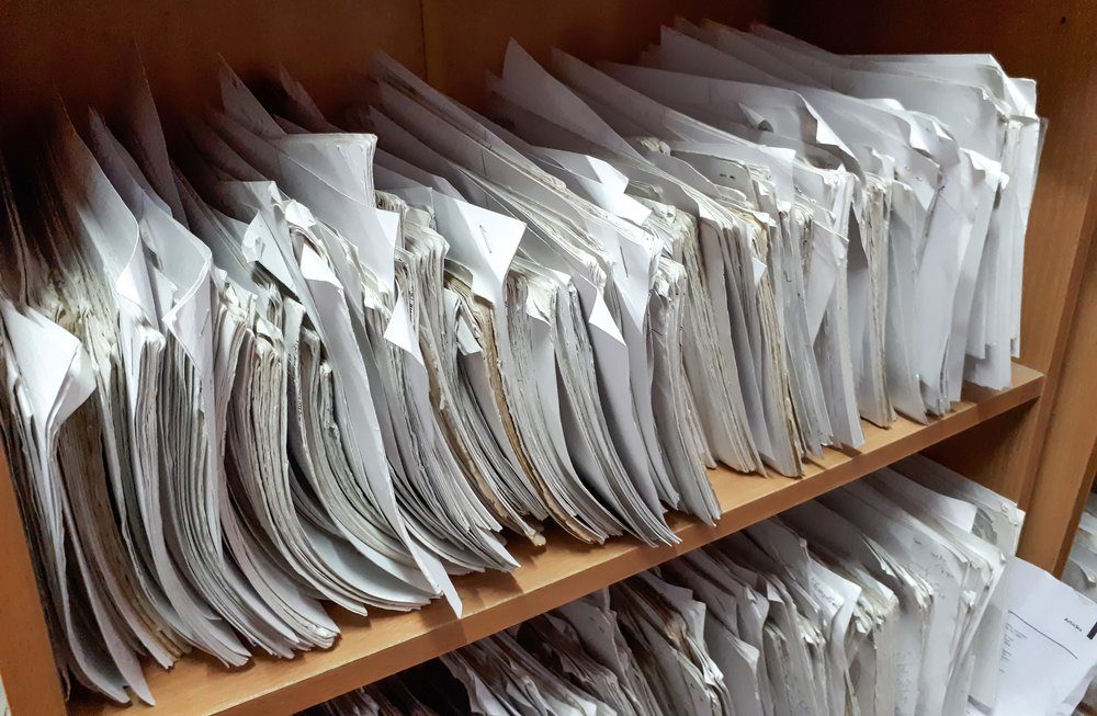 A cupboard full of paper files / inefficiency of paper based filing system