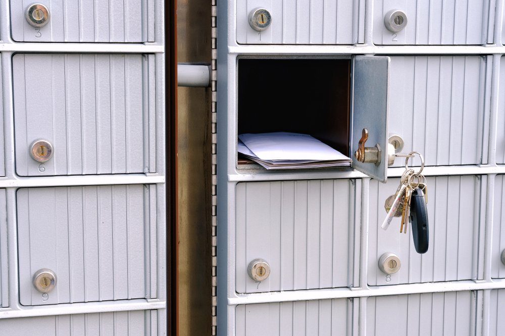 Open suburban mailbox door with keys dangling and mail visible in opening