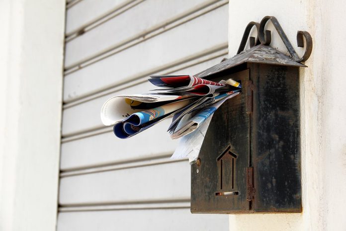 An old overloaded rusty mailbox waiting for someone to relieve if from the mail