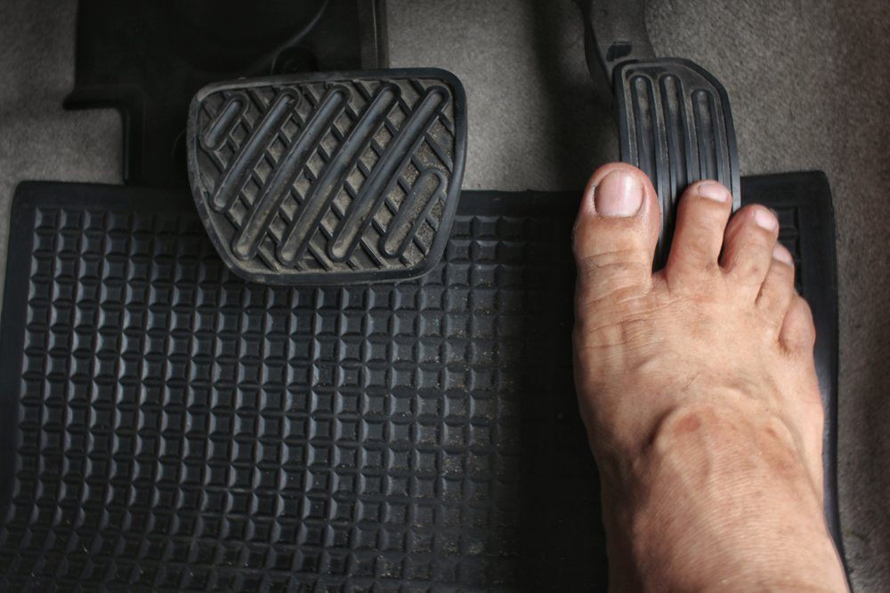 Close up driver's bare foot on pedal in car ,Safety to driving concept.