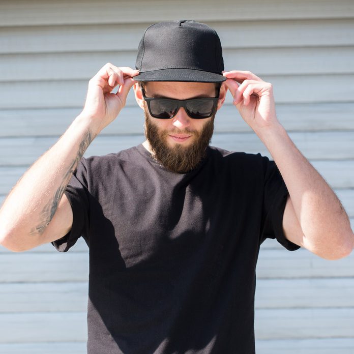 Hipster man wearing black T-shirt and a black hat with space for logo