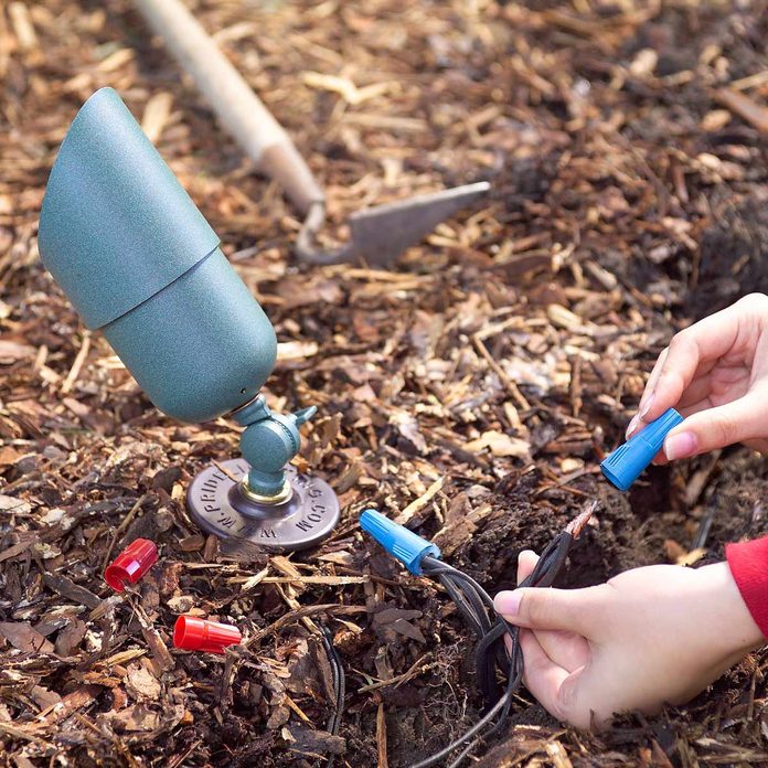 woman caps exposed outdoor lighting wires