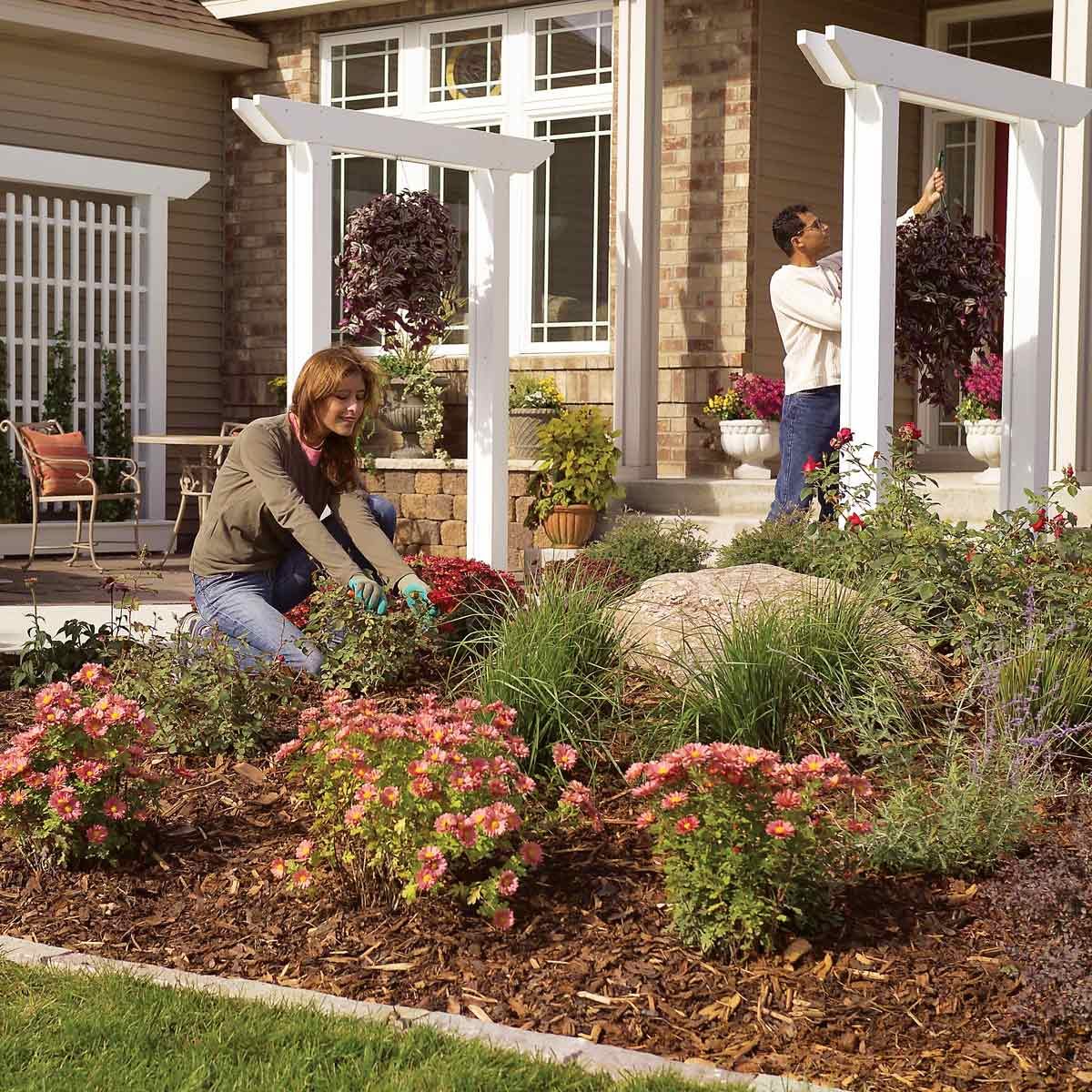woman kneels to garden in front yard