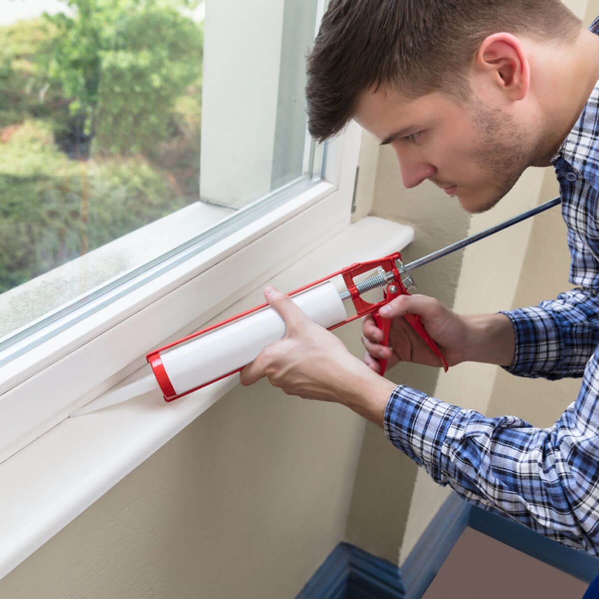 Caulk window shutterstock_686328526 caulk a window to keep your home warm