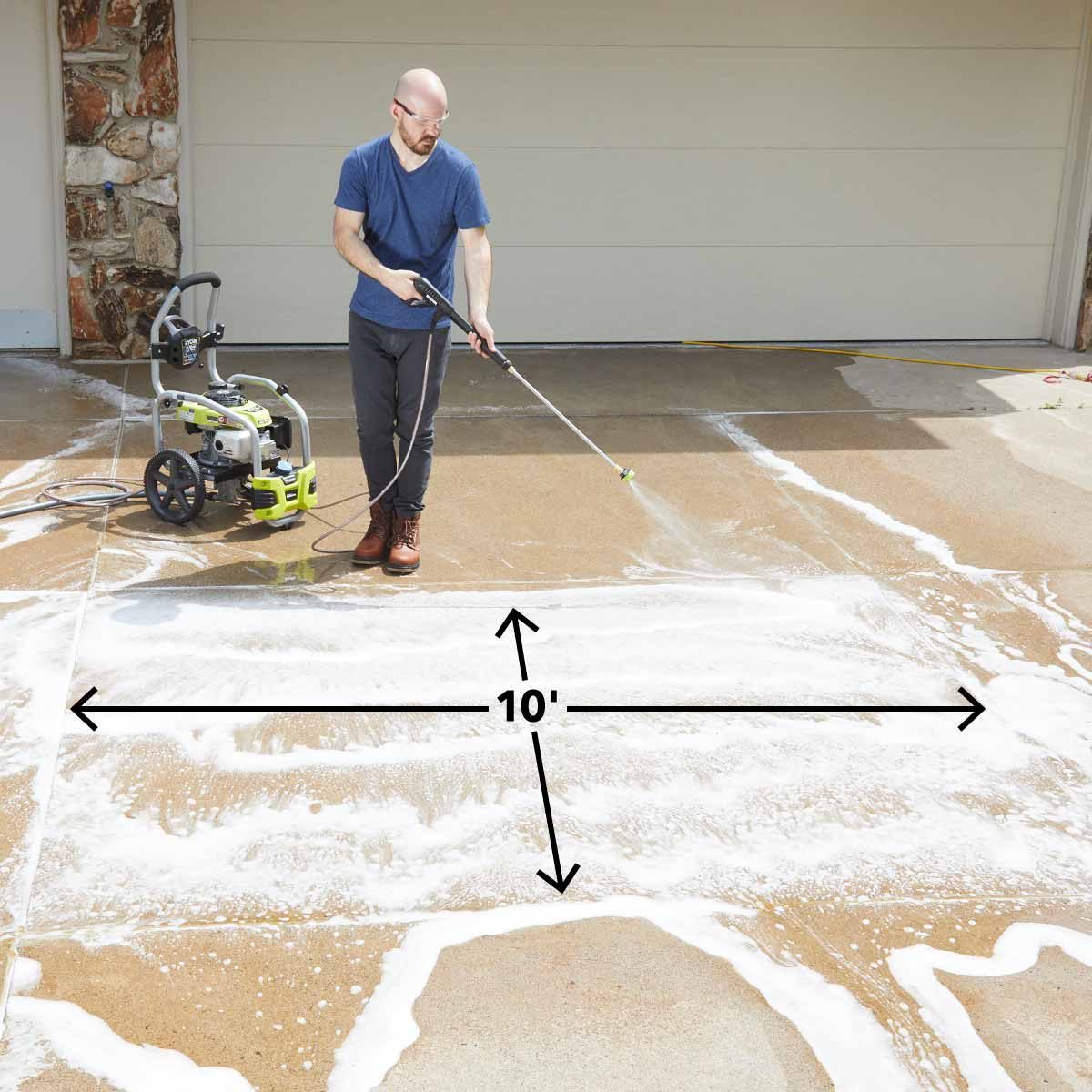 Spraying soap on concrete driveway