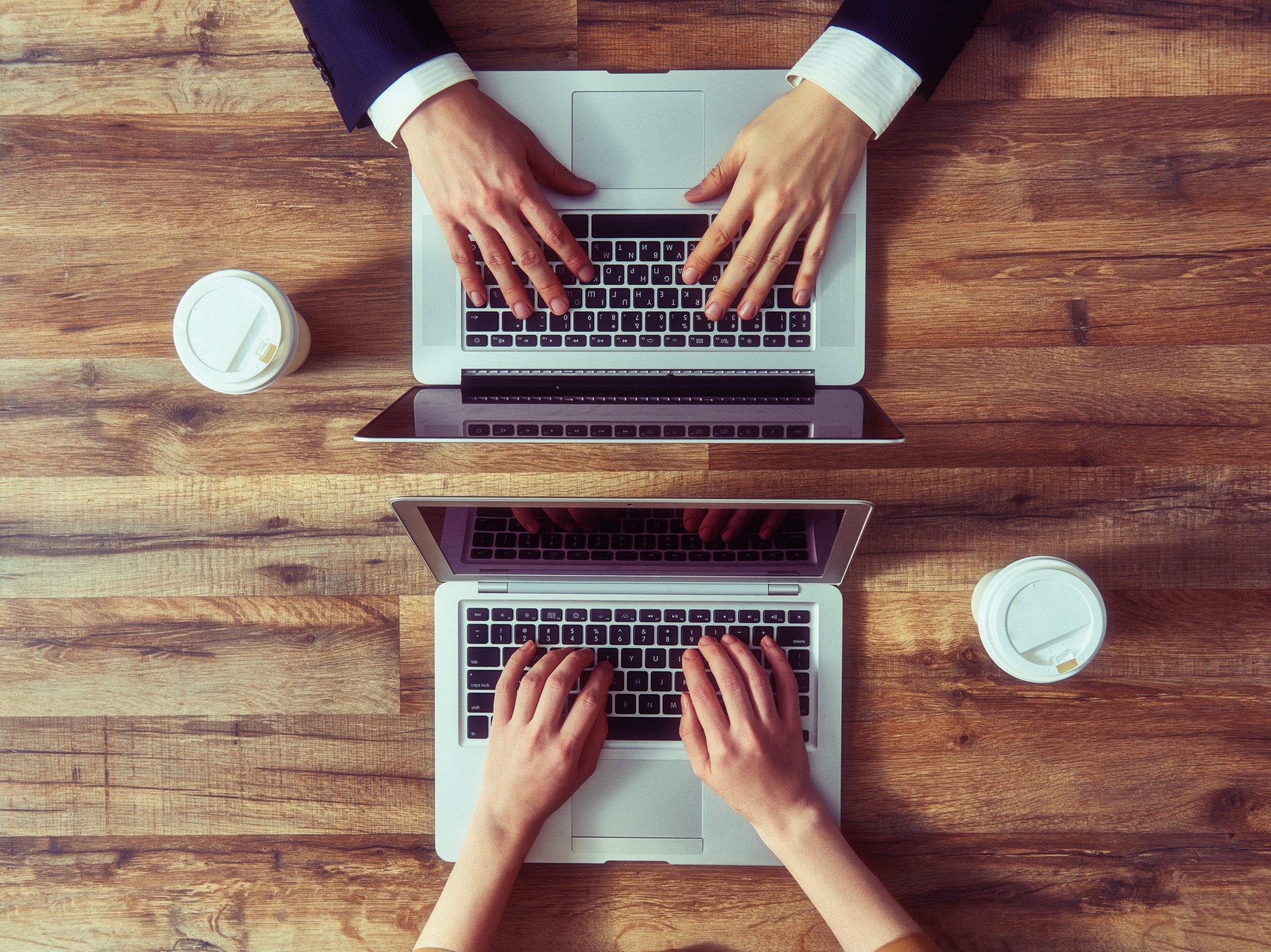 man and woman working on their computers. the view from the top. two laptops, two persons.