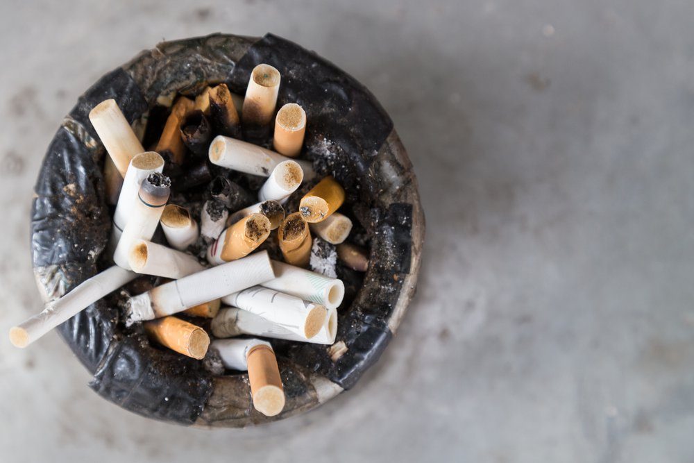 Overhead view of dirty and harmful cigarette butts in ash tray