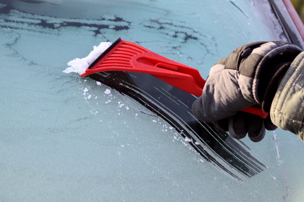 Scraping ice from the car window, with copy space