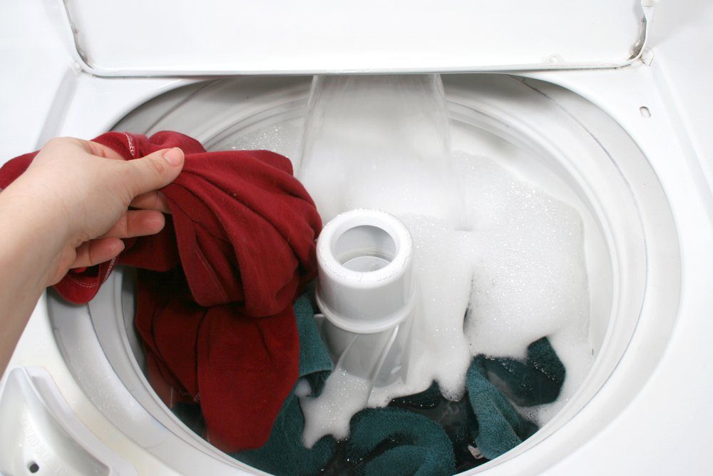 putting clothes into washer