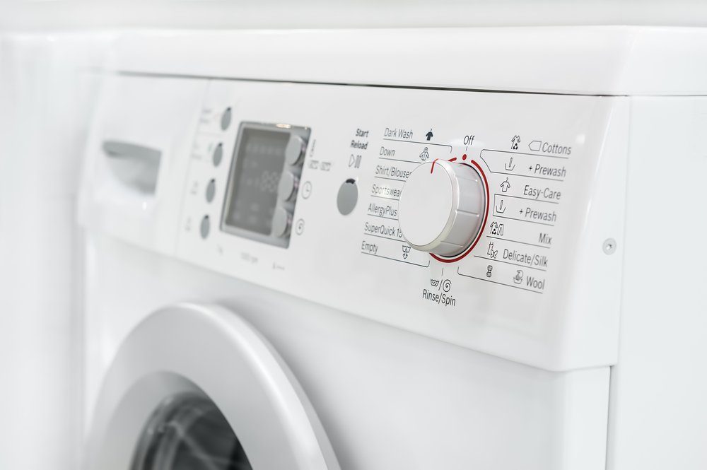 closeup of new white laundry or washing machine, selective focus on control elements