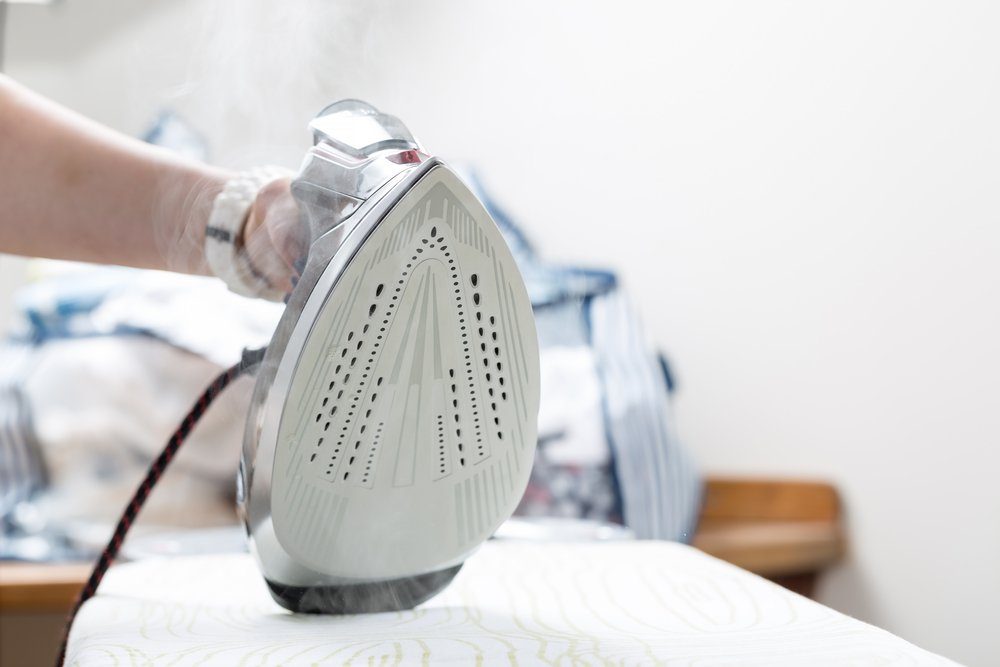 Woman uses irons, ironing at home.