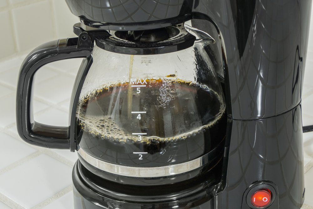 Coffee maker pot filling close up.