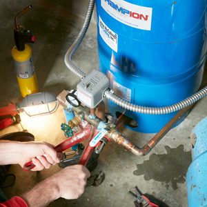 hands repairing well pump with pliers