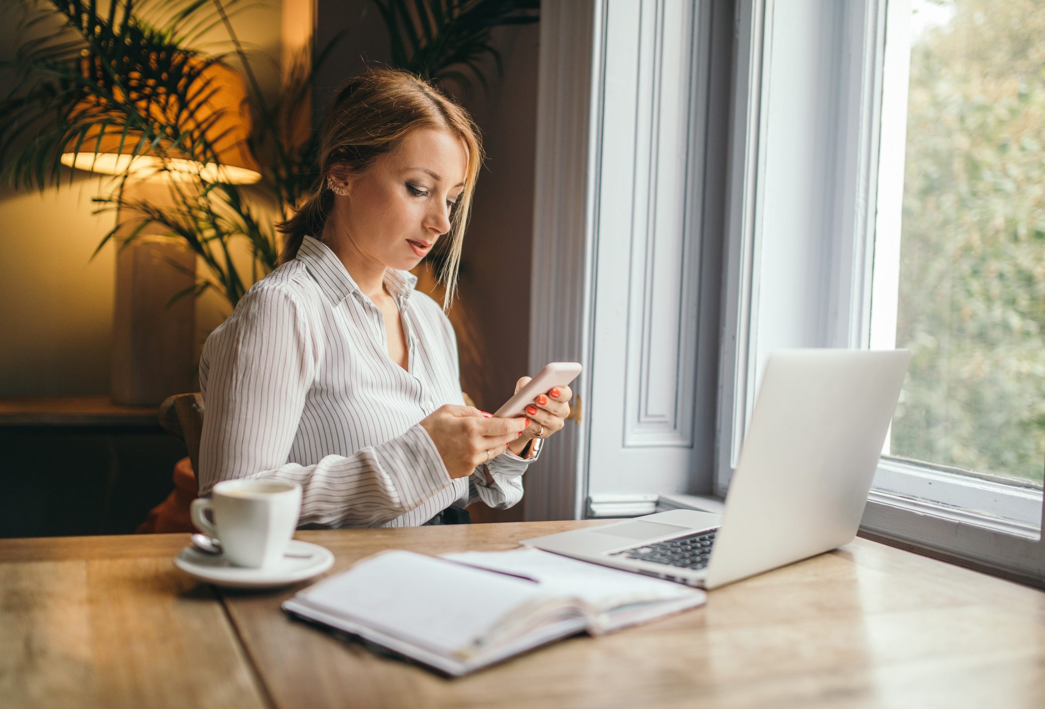 woman working and procrastinating on cell phone