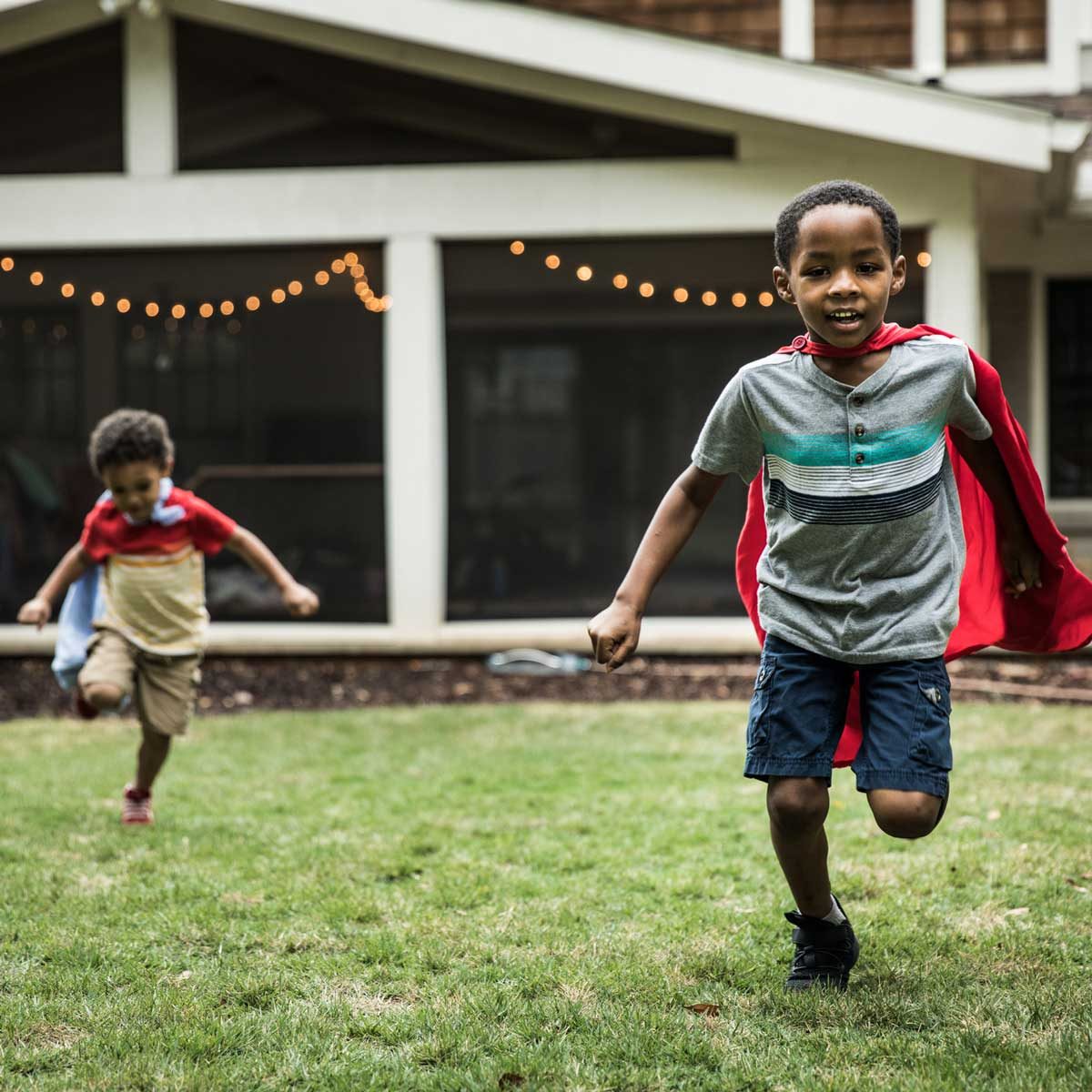 Two kids playing on a lawn