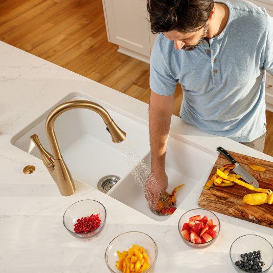 Man cutting veggies and putting some down the garbage disposal