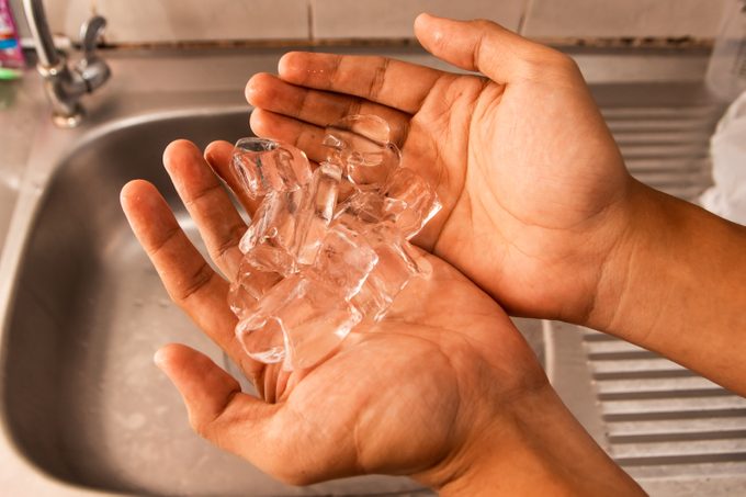 ice tube on hand on a kitchen sink