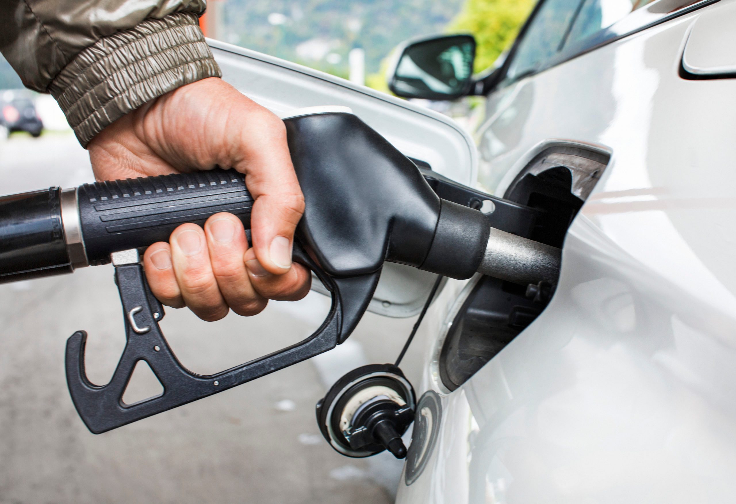 Mans's Hand Holding Fuel Nozzle In Car