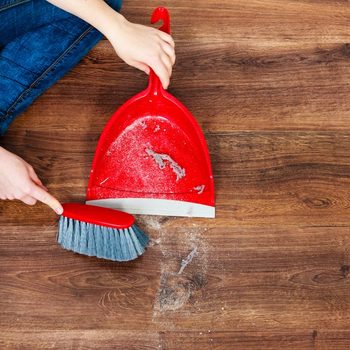 Cleanup Housework Concept Closeup Cleaning Woman Sweeping Wooden Floor With Red Small Whisk Broom And Dustpan Indoor