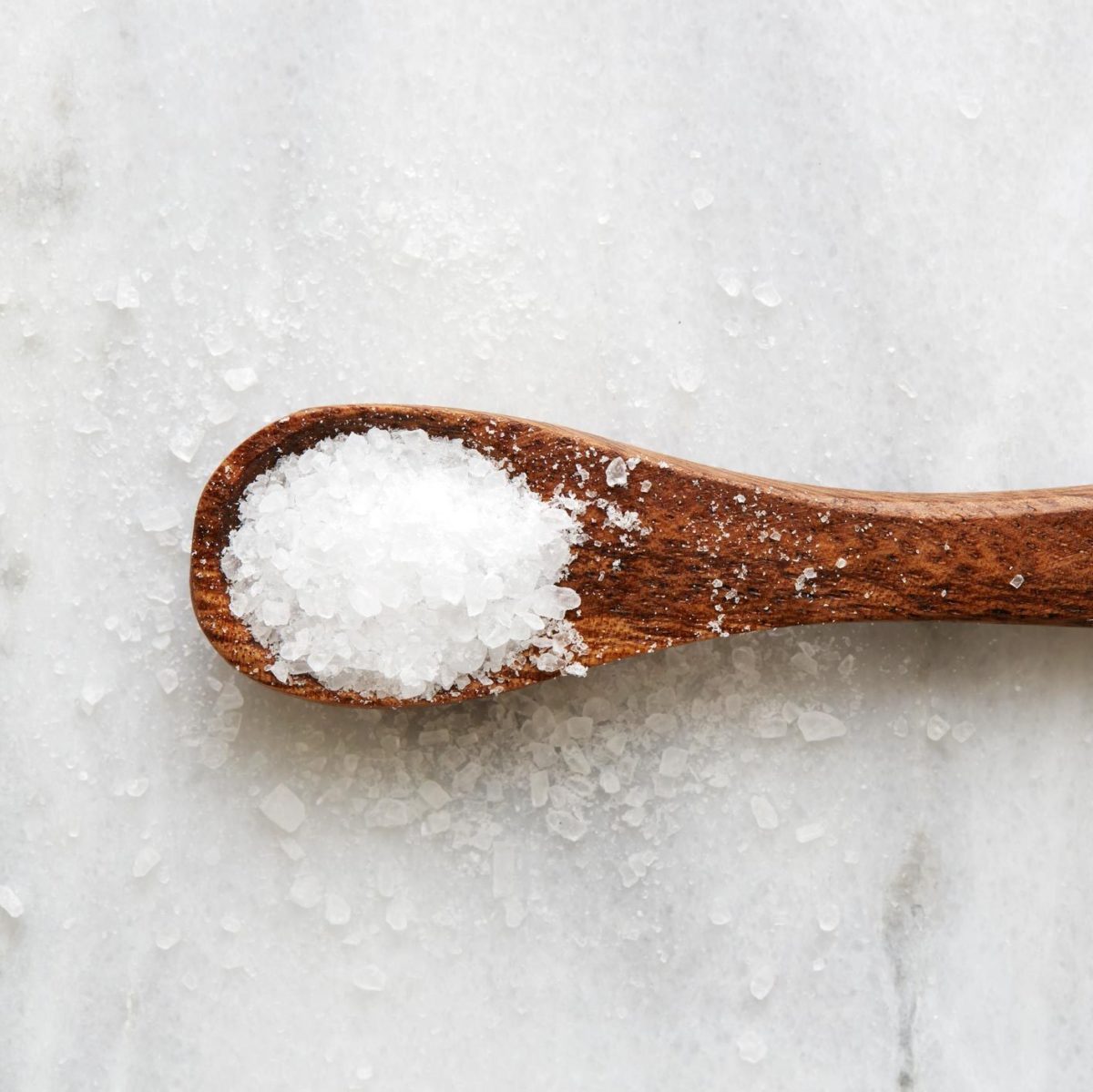 Overhead view of wooden spoon with sea salt