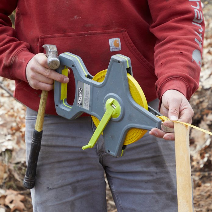 Man puts up a silt fence around Family Handyman's Getaway build