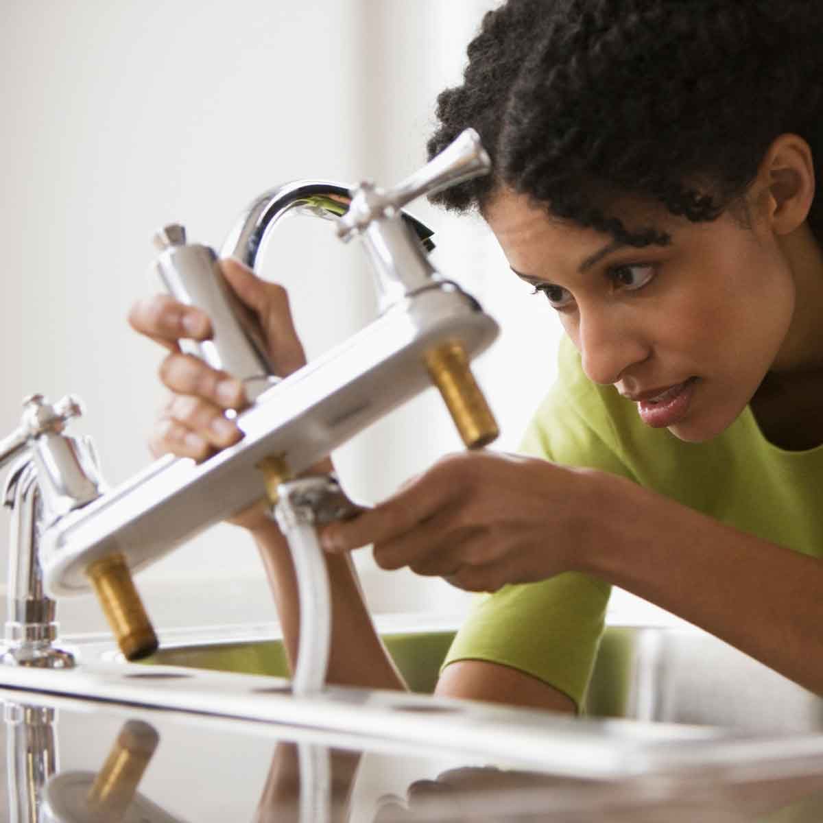 Woman Installing a Faucet