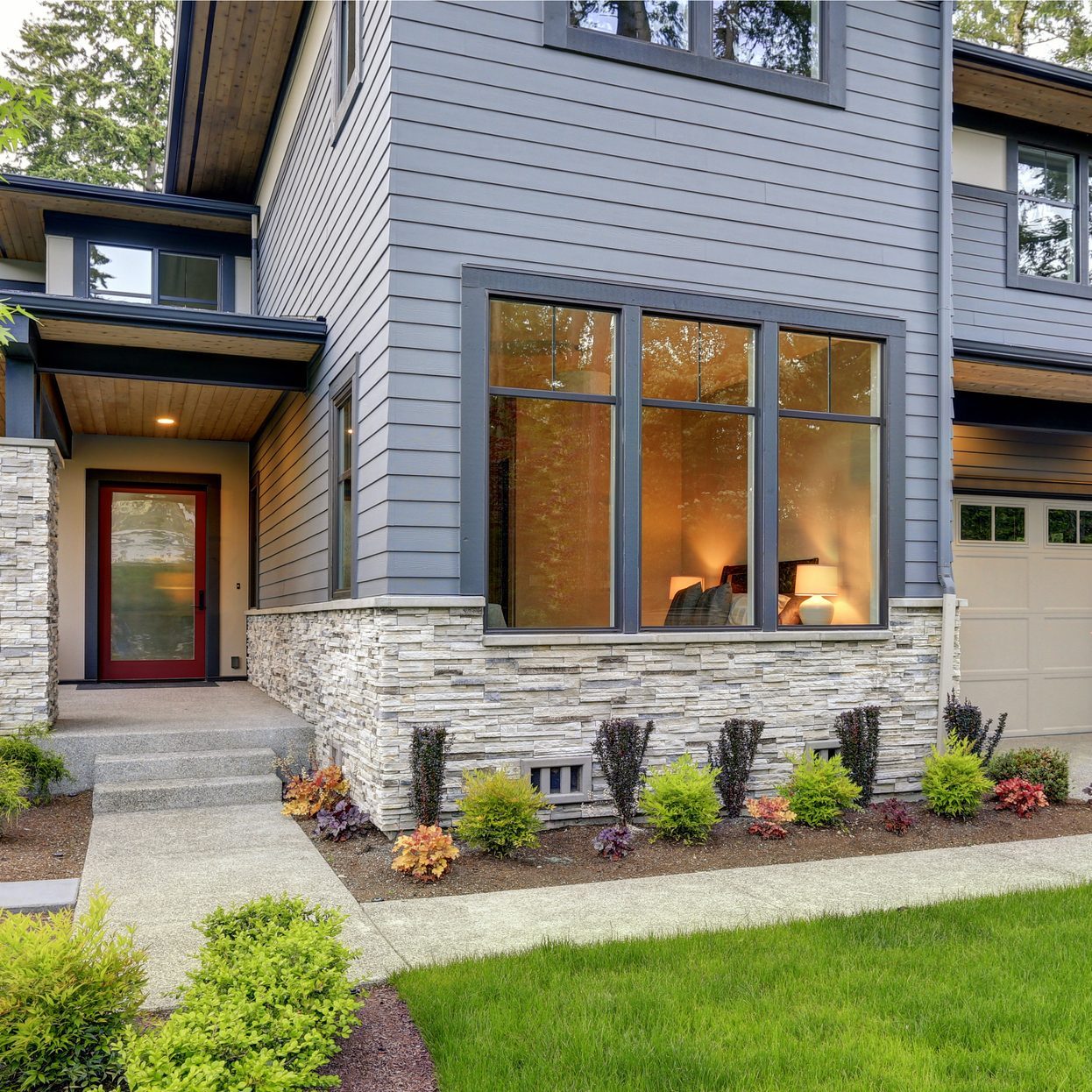 modern home from the front lawn; able to see into front room through the windows