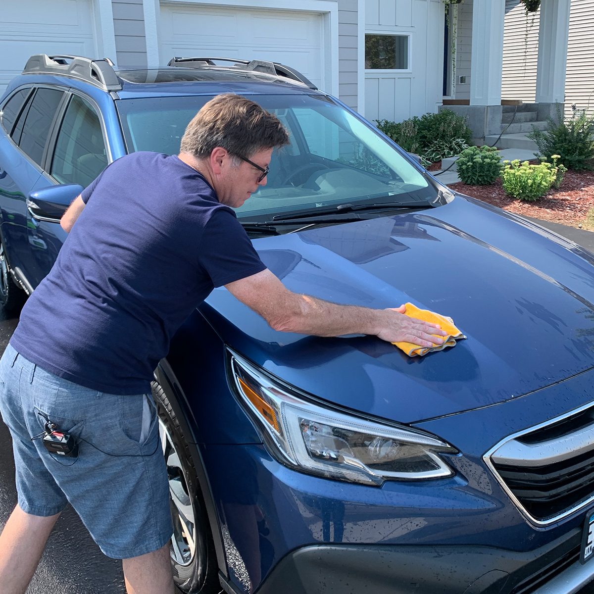 man drying his car after pressure washing