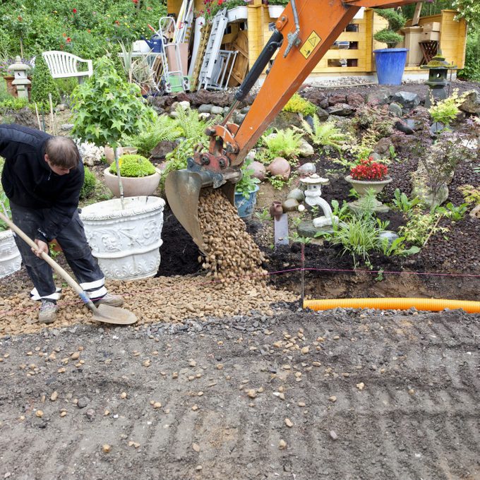 placing rocks and gravel over french drain pipe system