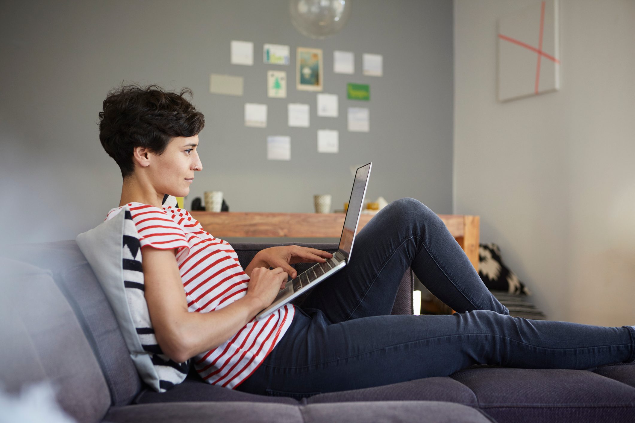 Woman using laptop on couch at home