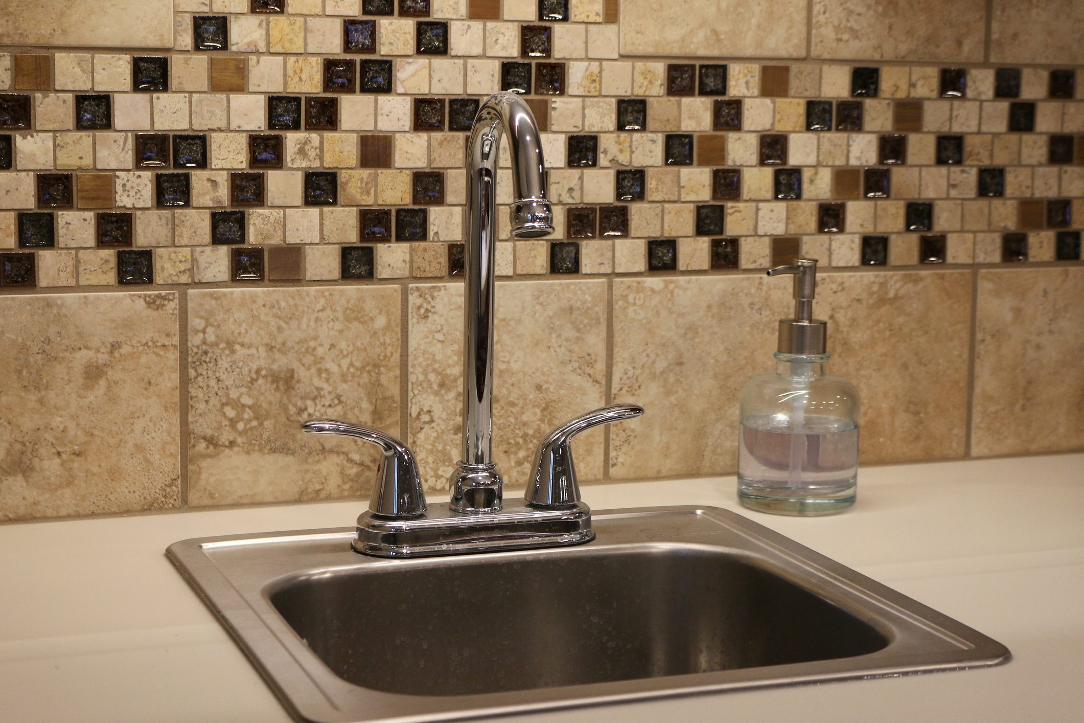 stainless steel Sink with brown tile