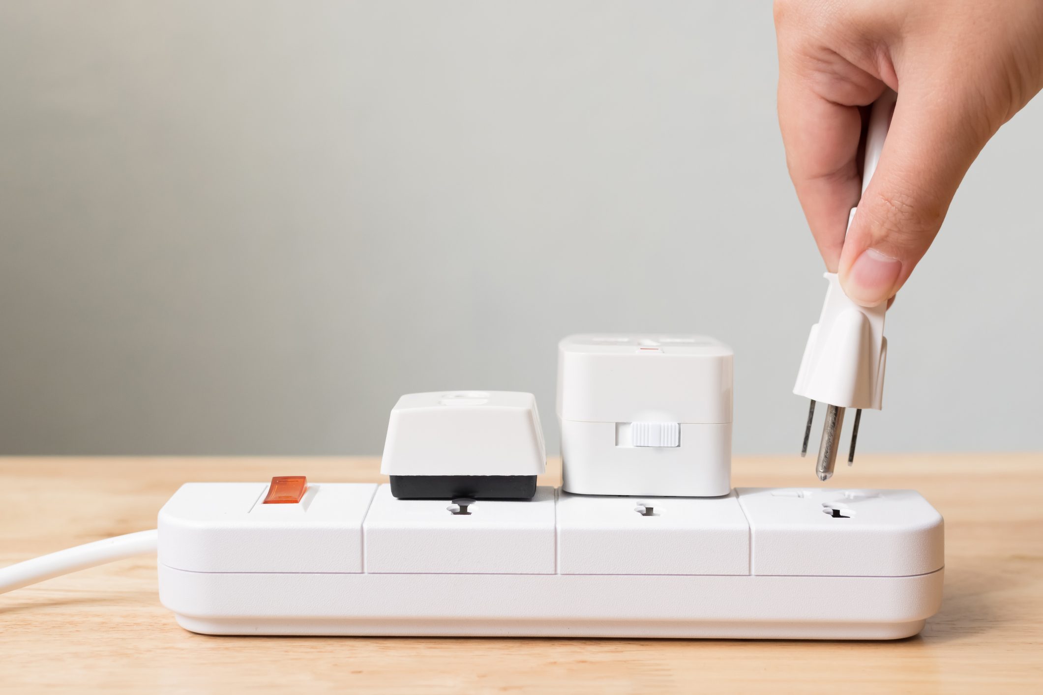 Close-Up Of Person inserting plug into power strip