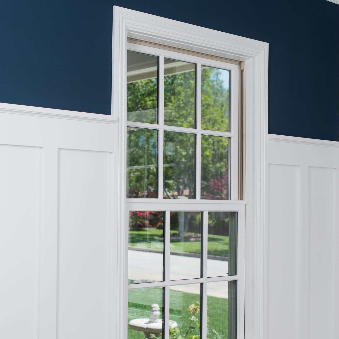white window trim with matching wainscotting on wall in bedroom of house