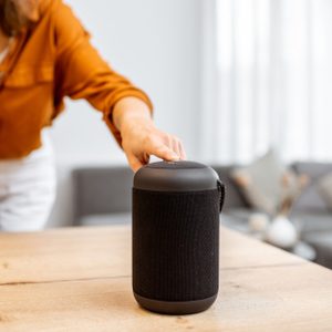 Woman with smart wireless column at home using IFTTT