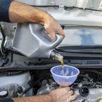 Pouring oil to car engine. stock photo