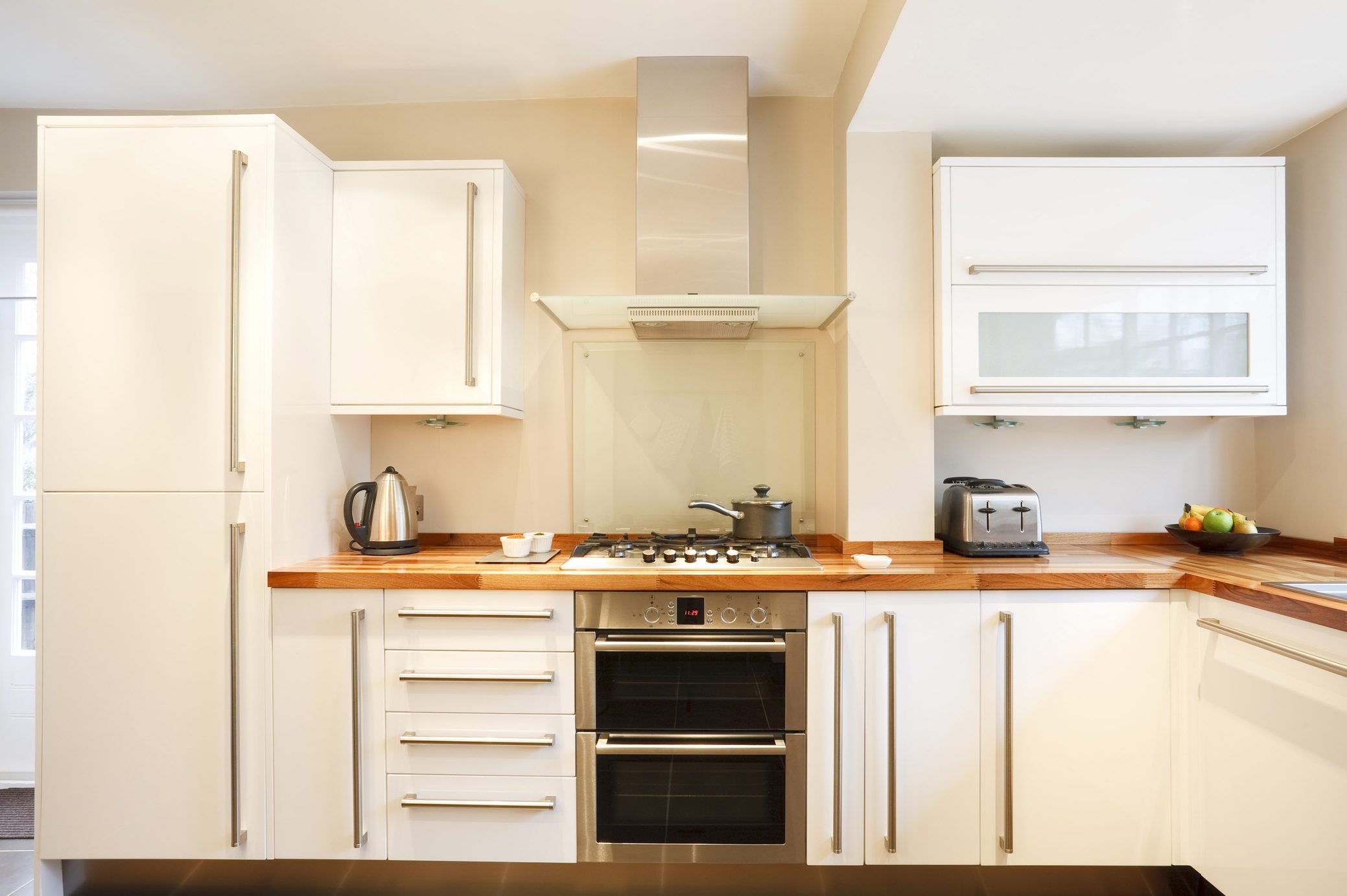 Modern white kitchen with wooden worktops and stainless steel appliances slab kitchen cabinets