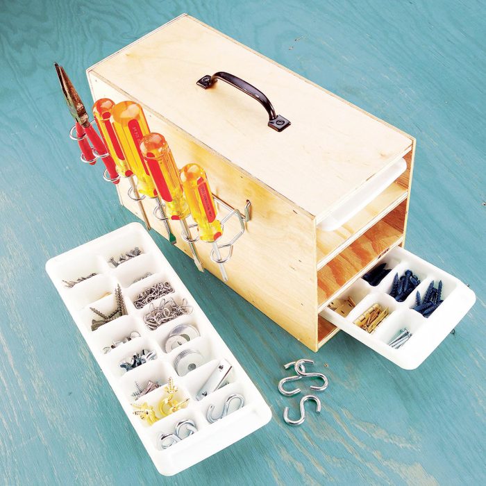 Ice Cube Tray Organizer with screws and hardware on a blue wooden background